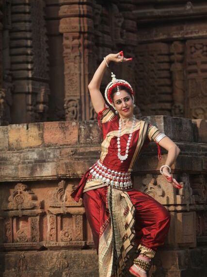 odissi girl dancing near temple